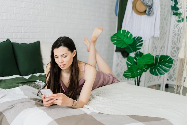 Vista recortada de manos femeninas sosteniendo teléfonos inteligentes. Mujer con teléfono celular en casa. Enfoque selectivo