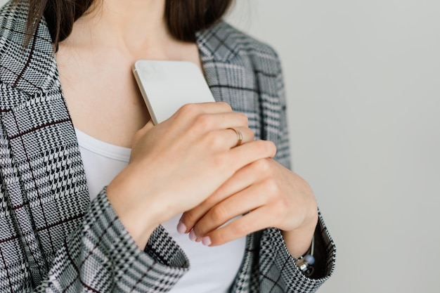 Vista recortada de manos femeninas sosteniendo teléfonos inteligentes. Mujer con teléfono celular en casa. Enfoque selectivo