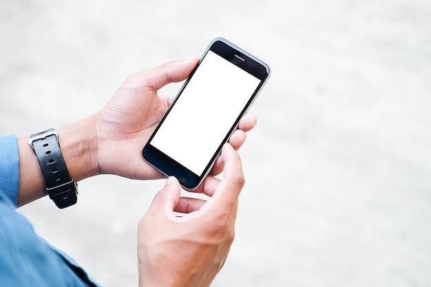 Vista recortada de las manos del hombre sosteniendo un teléfono inteligente con una pantalla de espacio de copia en blanco para su mensaje de texto o contenido de información femenino leyendo un mensaje de texto en el teléfono celular durante el entorno urbano