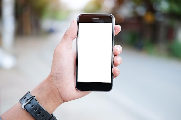 Vista recortada de las manos del hombre sosteniendo un teléfono inteligente con una pantalla de espacio de copia en blanco para su mensaje de texto o contenido de información femenino leyendo un mensaje de texto en el teléfono celular durante el entorno urbano