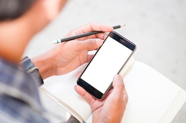 Vista recortada de las manos del hombre sosteniendo un teléfono inteligente con una pantalla de espacio de copia en blanco para su mensaje de texto o contenido de información femenino leyendo un mensaje de texto en el teléfono celular durante el entorno urbano