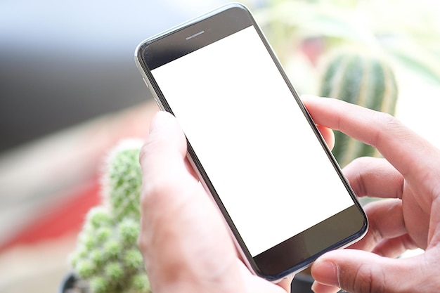 Vista recortada de las manos del hombre sosteniendo un teléfono inteligente con una pantalla de espacio de copia en blanco para su mensaje de texto o contenido de información femenino leyendo un mensaje de texto en el teléfono celular durante el entorno urbano