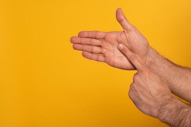 Vista recortada de manos masculinas mostrando gesto en lenguaje sordo y mudo aislado en amarillo