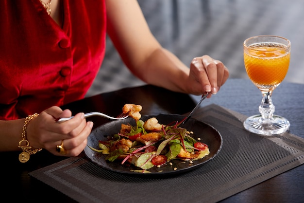 Vista recortada de la mujer comiendo ensalada fresca para el almuerzo en un restaurante de lujo dieta de estilo de vida saludable