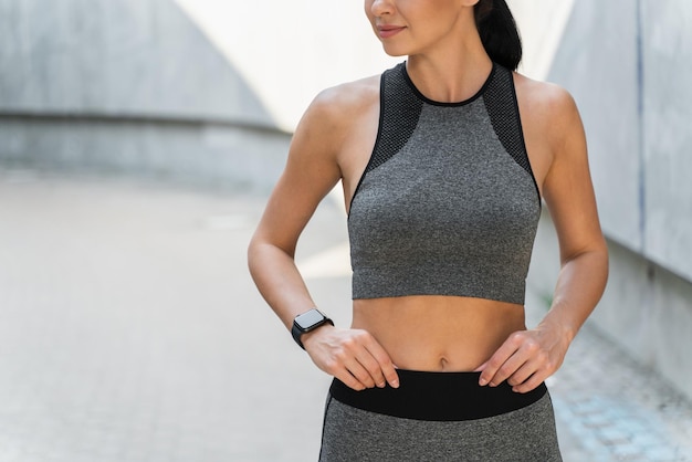 Vista recortada de la mujer deportiva con cuerpo perfecto de pie en el estadio con calma y posando para la cámara Concepto de deporte y personas