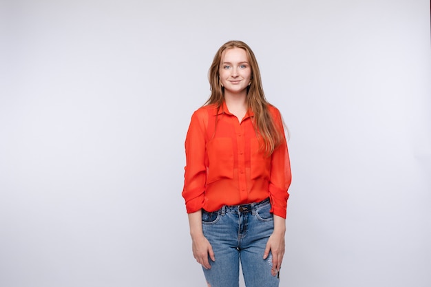 Vista recortada de mujer vestida con camisa roja y jeans de pie