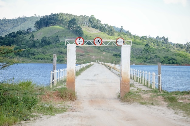 Foto vista represa com pescador com muito sol tropical de verão e cães nadando