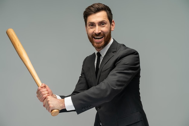 Vista de retrato de cintura para arriba del hombre de negocios caucásico con un bate de béisbol de pie sobre fondo gris Concepto de ocupación