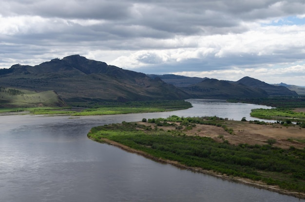 Vista del río desde un alto cerro A orillas del río hay montañas y cerros