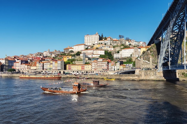 Vista del río Duero y la ciudad de Oporto grandes barcos con barriles de vino oporto el puente más famoso y barcos para transportar vino