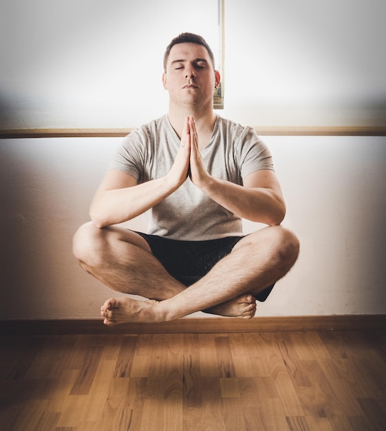 Vista serena de un joven de España meditando en posición de loto