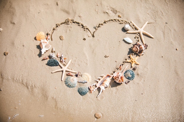 Vista del símbolo del corazón de amor dibujado en la playa de arena