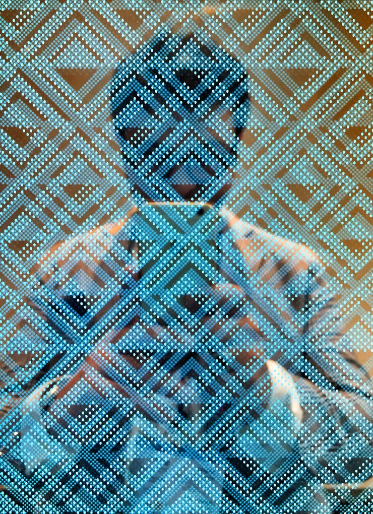 Foto vista simétrica de um homem fotografando-se refletindo vidro padronizado