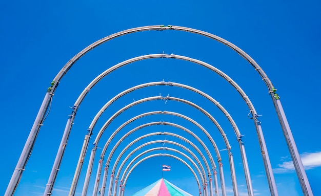 Vista simétrica de la estructura del patio de recreo del túnel de acero con carpa de carrusel colorida contra el cielo azul