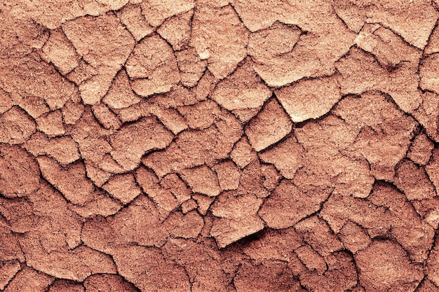 Vista Sloseup de um plano de fundo texturizado com uma aparência de terra rachada seca em uma cor marrom-avermelhada