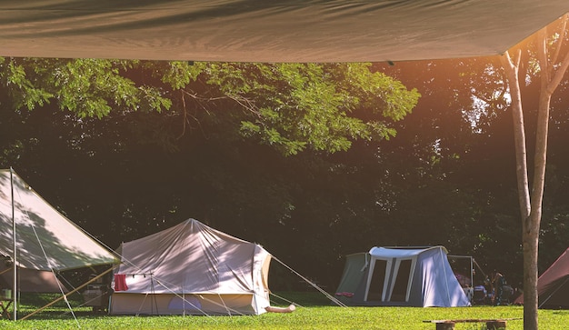 Vista sob a tela do para-sol das barracas de campo à sombra das árvores na área do acampamento