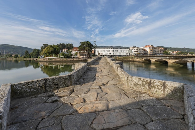 Vista sobre a ponte românica que atravessa o rio Menor em La Ramallosa que liga Baiona a Nigran na Galiza Espanha uma bela manhã de verão com águas calmas