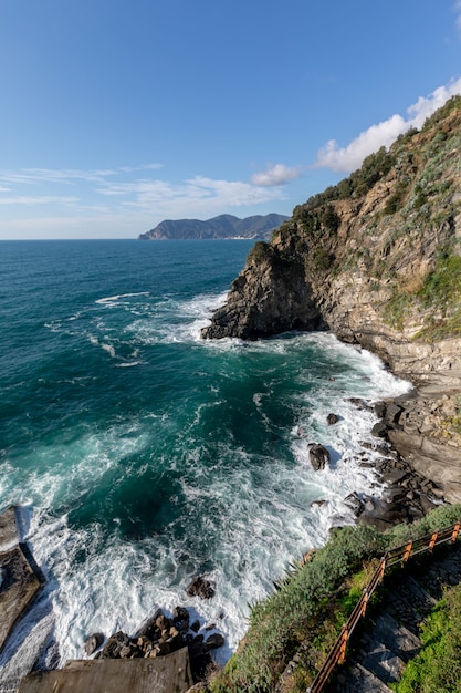 Foto vista sobre cinque terre e as ondas do mar de corniglian