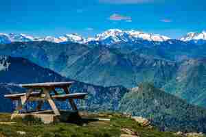 Foto vista sobre la cordillera de los pirineos cubierta de nieve y una mesa picínica en la cumbre del tuc de l