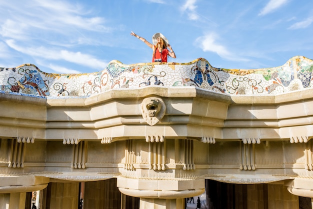 Foto vista sobre la hermosa terraza decorada con mosaico con turista mujer feliz en el parque güell de barcelona