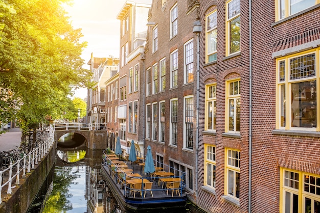 Vista sobre los hermosos edificios antiguos y el canal de agua en la ciudad de Delft durante la luz de la mañana, Países Bajos