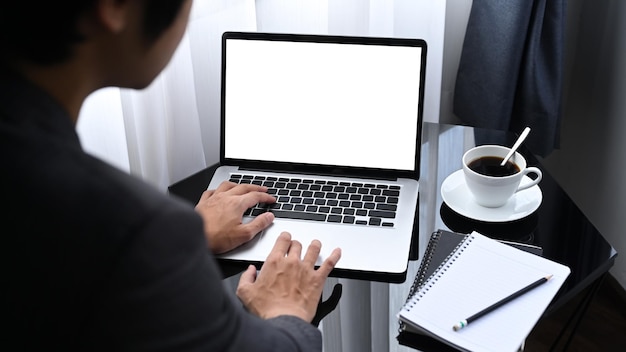 Vista sobre el hombro del hombre de negocios trabajando con una laptop en la oficina