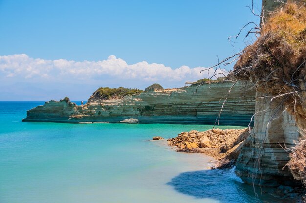 Vista sobre la increíble bahía de las montañas rocosas de la isla en el agua azul clara del mar Jónico y las rocas verdes de las cuevas azules