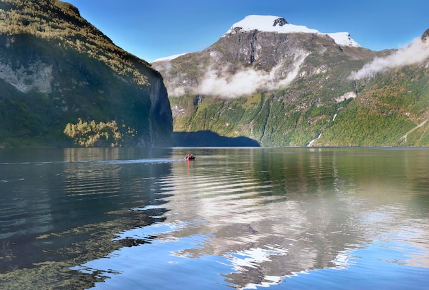 Vista sobre o belo fiorde de Geiranger, na Noruega, com reflexo da montanha na água