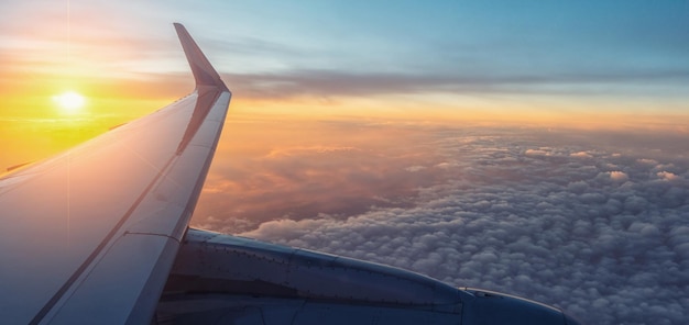 Vista sobre o pôr do sol e a asa do avião por dentro