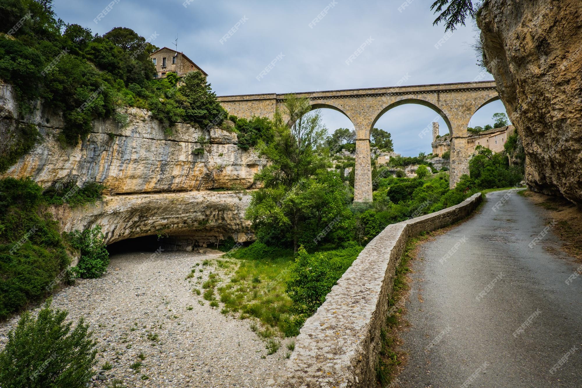 Vista sobre o rio cesse, a ponte, a gruta grand pont naturel e a aldeia de  minerve, herault