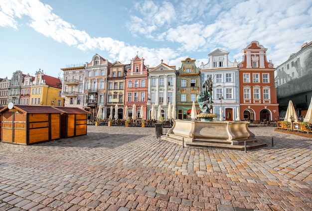 Vista sobre os belos edifícios antigos com a fonte de netuno na praça maket na cidade de poznan durante a luz da manhã na polônia