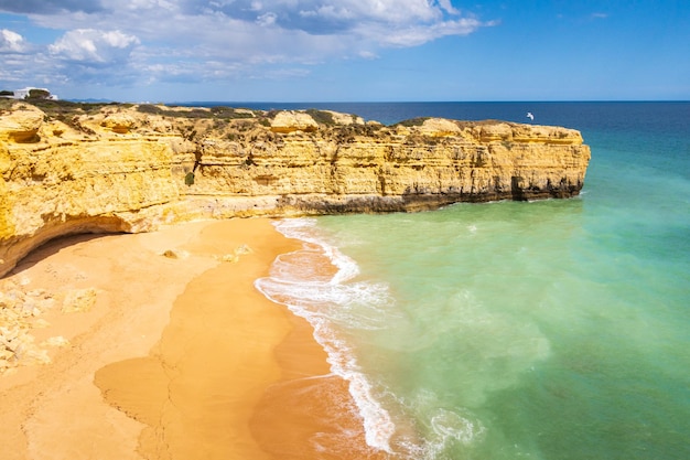 Vista sobre penhascos e ondas oceânicas batendo na praia perto de Albufeira, Portugal