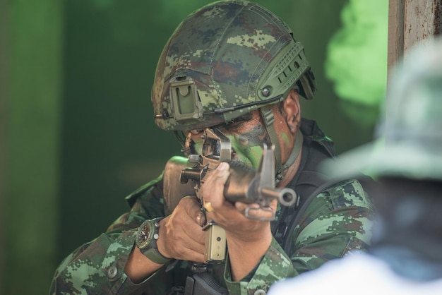 Foto vista de un soldado con un rifle de pie al aire libre