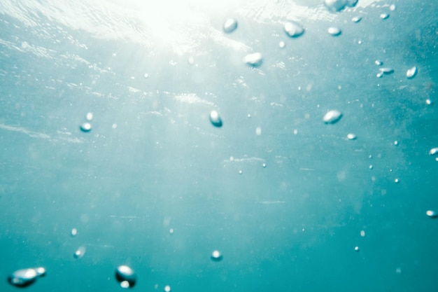 Vista subaquática de bolhas no oceano azul profundo, perto do fundo da água