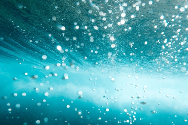 Foto vista submarina de burbujas en el mar azul profundo cerca del fondo del agua