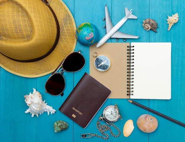 Vista superior de los accesorios de viaje en el piso de tablones de madera azul claro para el tiempo de vacaciones de verano