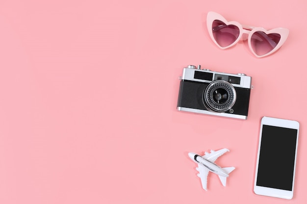 Vista superior de accesorios de viaje sobre fondo de color rosa, concepto de viaje. Lay Flat, copia espacio