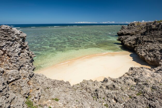 Vista superior de la acogedora playa llena de corales arenas vírgenes rodeadas por acantilados de la playa de Tatehara Japón