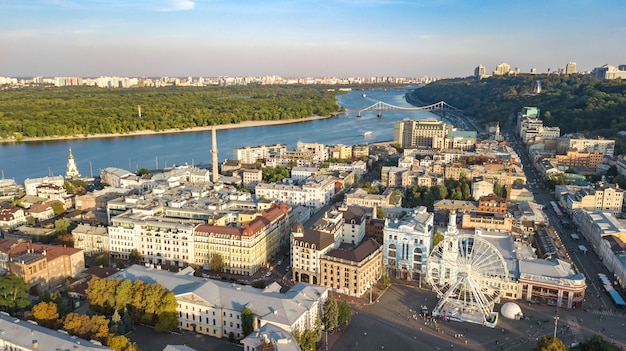 Vista superior aérea da paisagem urbana de kiev, rio dnieper e skyline do distrito histórico de podol de cima, praça kontraktova com roda gigante, cidade de kiev, ucrânia