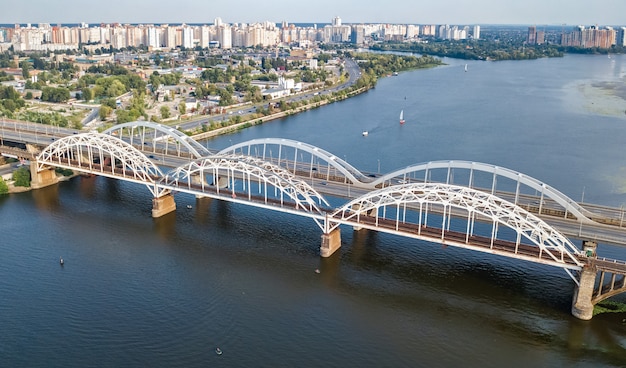 Foto vista superior aérea da ponte darnitsky, automóvel e ferrovia, sobre o rio dnieper, acima, horizonte da cidade de kiev (kyiv), ucrânia