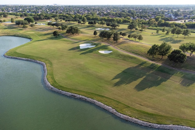 Vista superior aérea de un parque verde en la costa del lago hermoso campo de golf verde