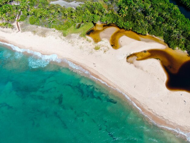 Vista superior aérea de la playa tropical de arena blanca y agua de mar turquesa clara con olas pequeñas