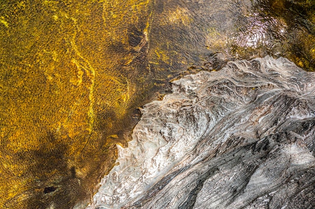 Vista superior del agua de un río y un banco de rocas El viento le da al conjunto una textura soberbia