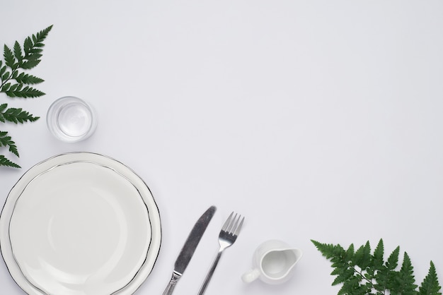 Vista superior del ajuste del plato de cena. Plato vacío y cubiertos en mesa de madera