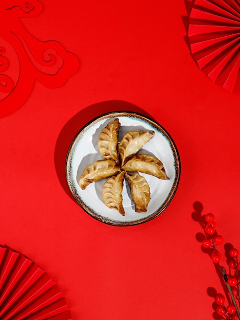 Vista superior de las albóndigas chinas (Jiaozi) dispuestas en círculo en un plato redondo blanco