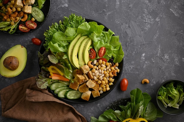 Vista superior de un alimento a base de plantas sobre fondo oscuro Tofu a la parrilla con verduras de nueces de garbanzo