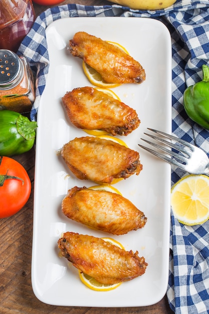 Vista superior de alitas de pollo sobre rodajas de limón
