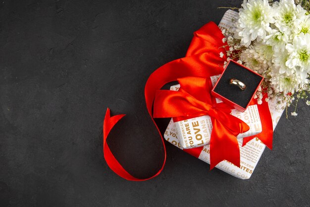 Vista superior del anillo de flores de regalo del día de San Valentín en caja sobre fondo oscuro con lugar para copiar