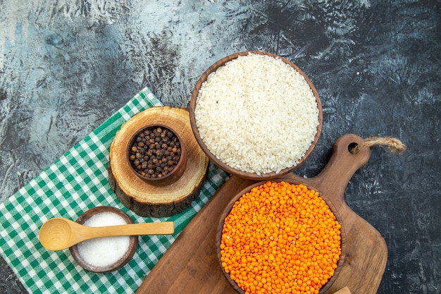 Vista superior de arroz crudo con lentejas naranjas sobre fondo oscuro alimentos semillas harina sémola sopa cereales de color