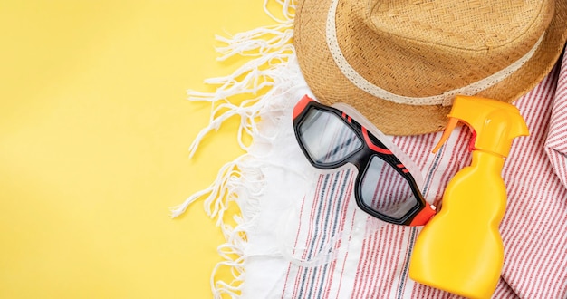 Vista superior de artículos de vacaciones de verano Sombrero máscara de natación crema de protección solar y toalla de playa